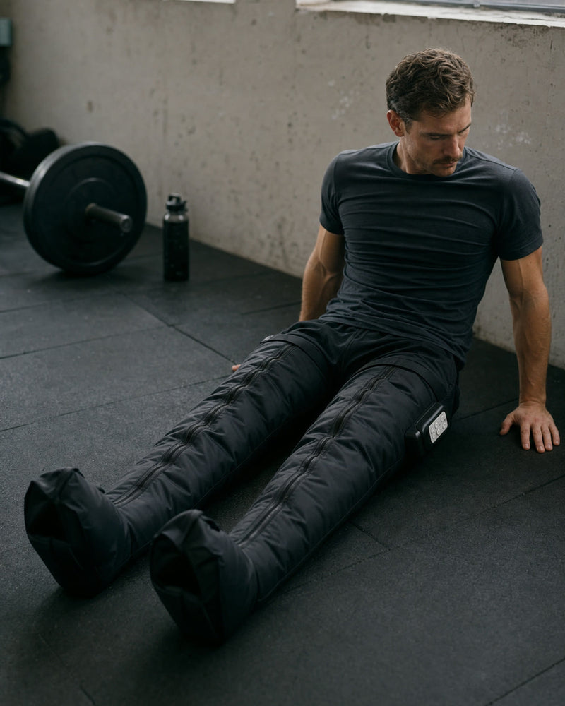 Athlete recovering on a gym floor wearing Flow 2 boots
