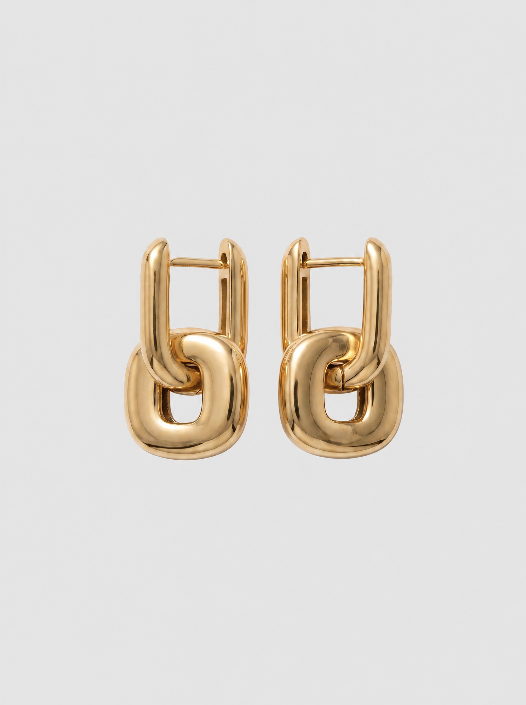 Vela 18K geometric earrings on soft grey background
