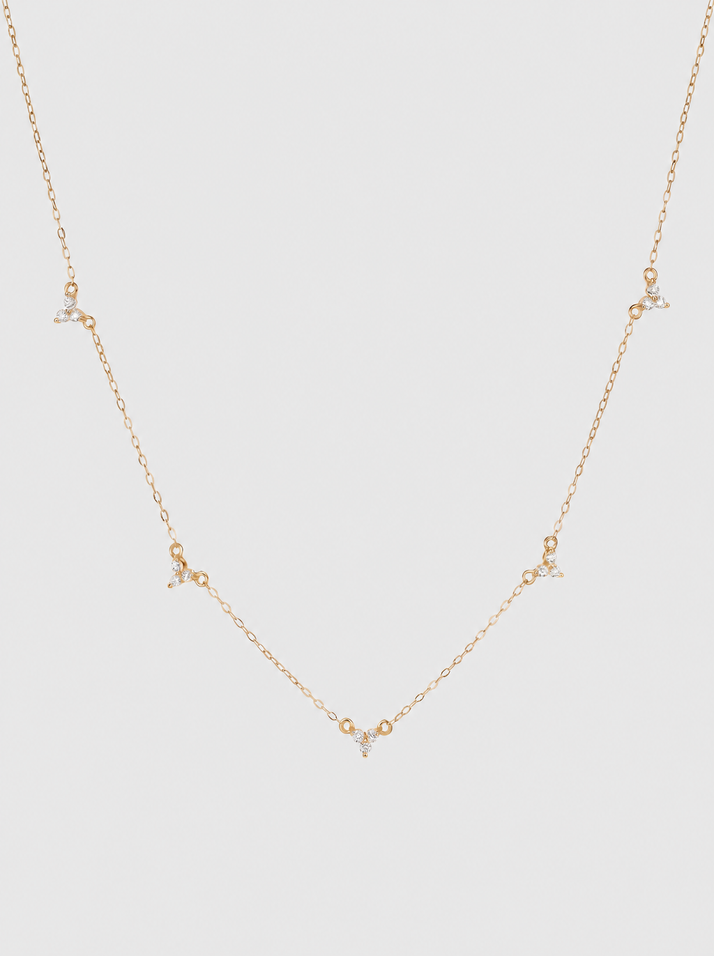 Stella 18K star necklace on soft grey background