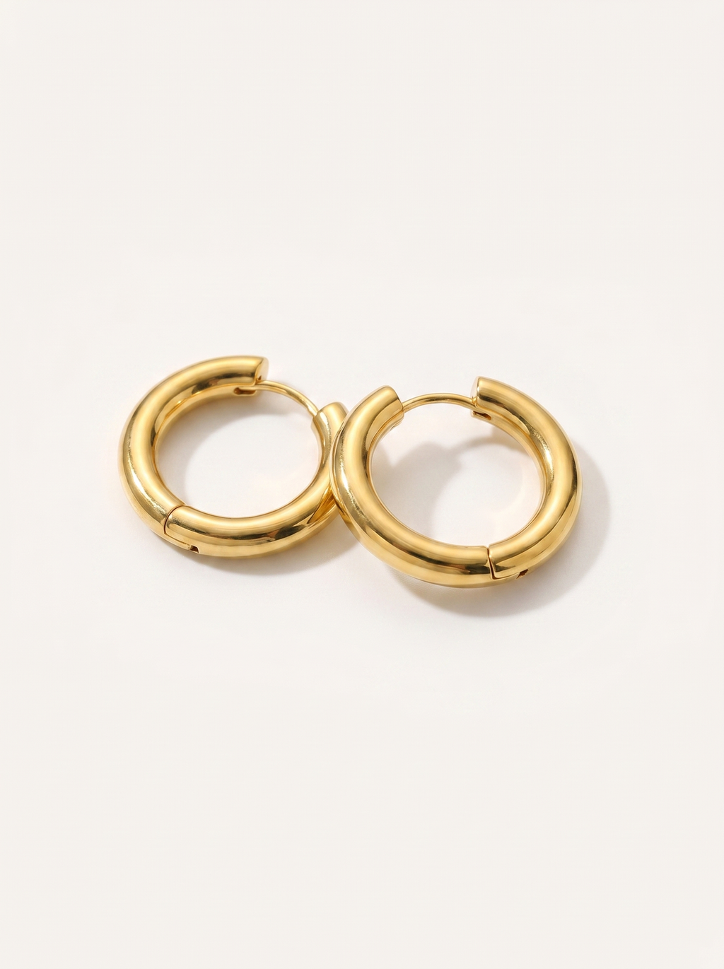 Cercle 18K gold huggie hoop earrings on clean white background