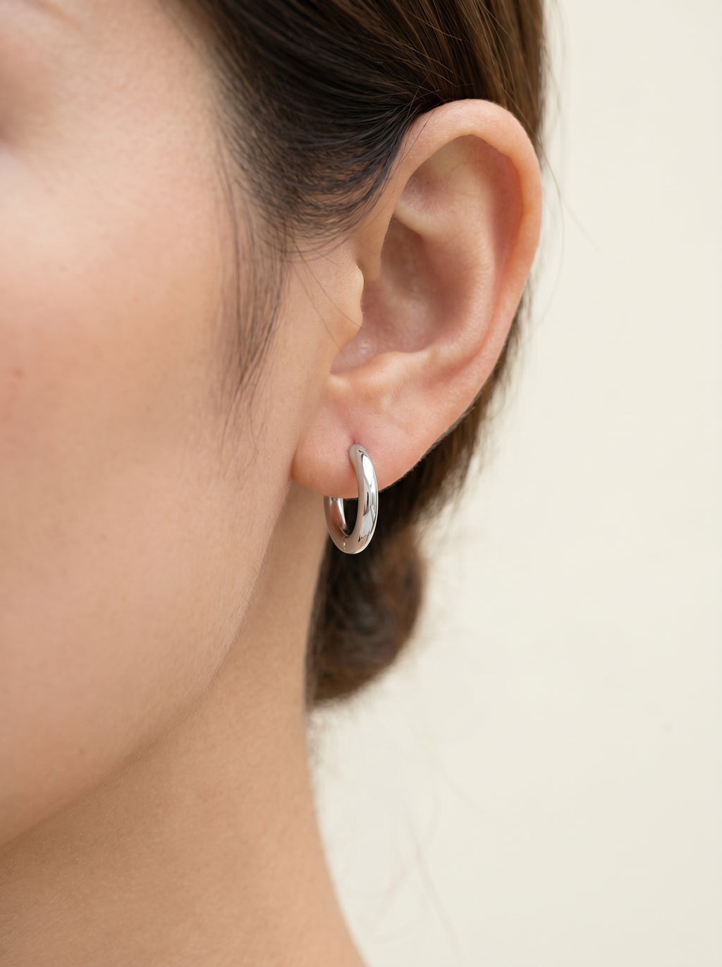Cercle silver huggie hoop earring worn on the ear
