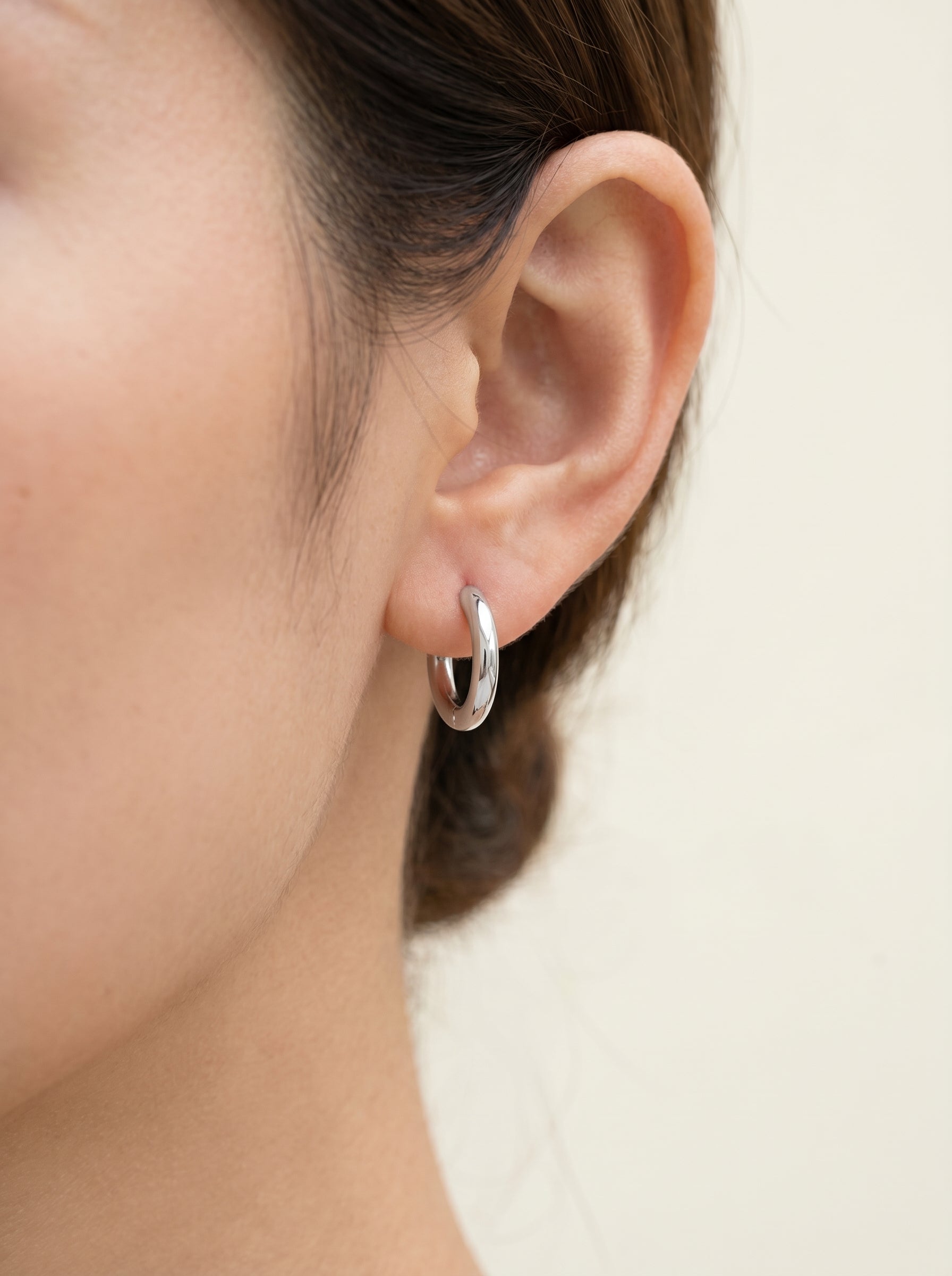 Cercle silver huggie hoop earring worn on the ear