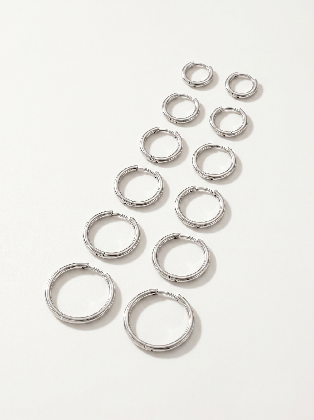 Cercle silver huggie hoop earrings on clean white background