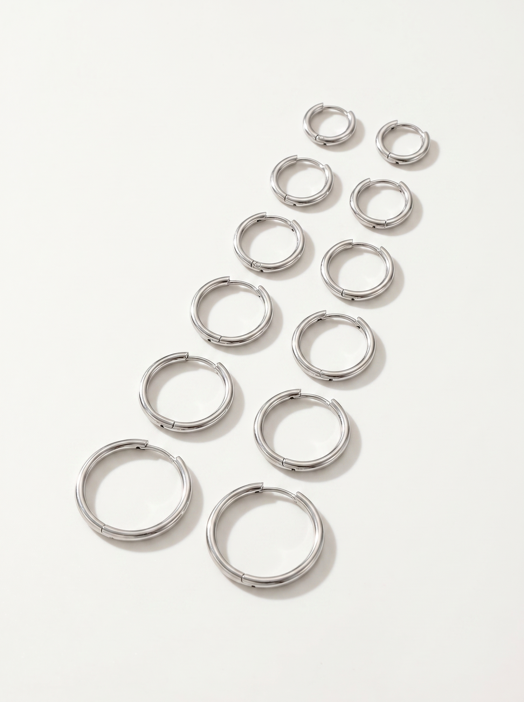 Cercle silver huggie hoop earrings on clean white background
