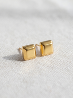 Carre gold cube stud earrings macro detail on linen