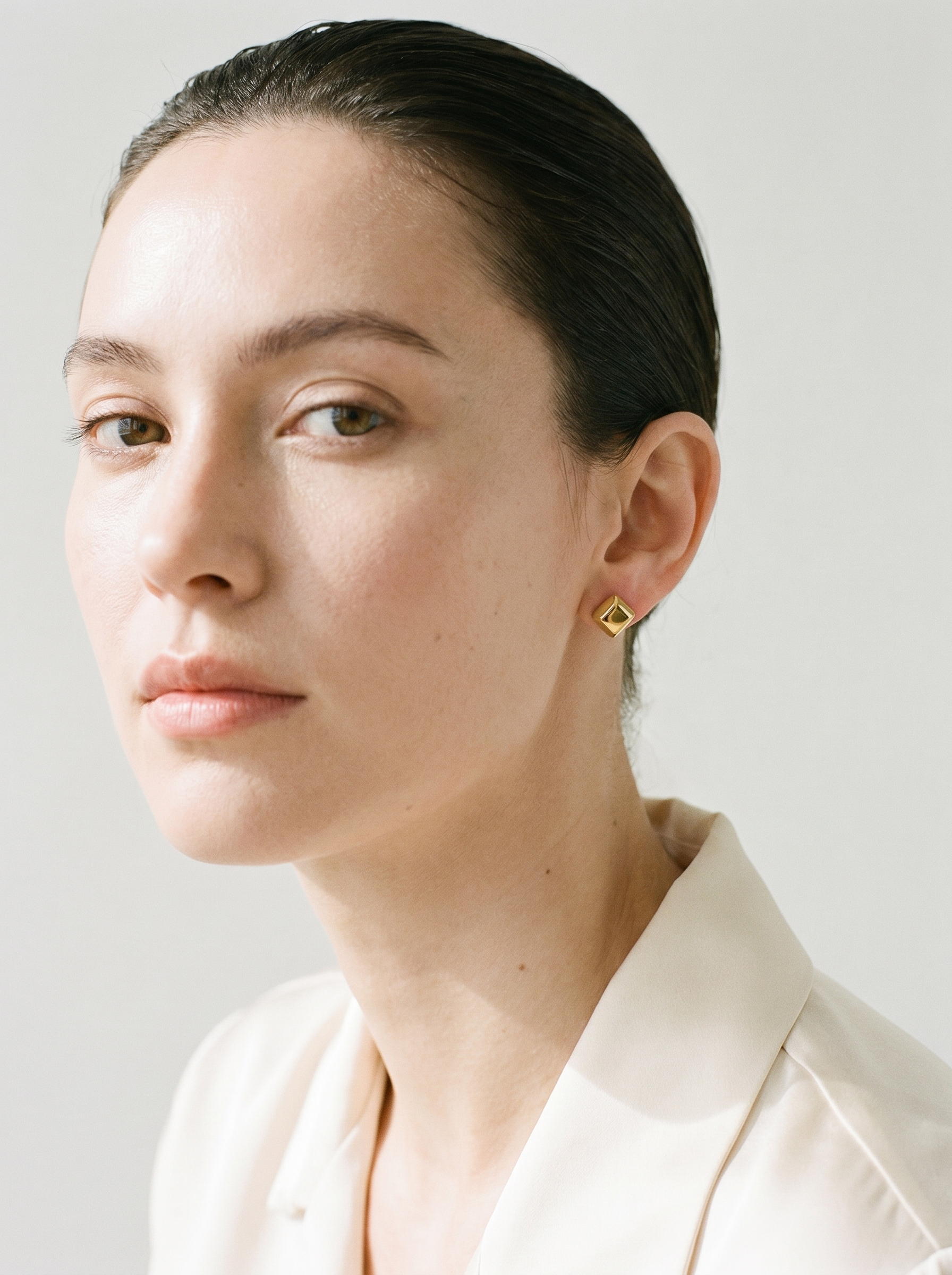 Carre gold cube stud earrings editorial portrait