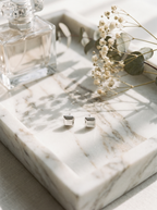 Carre silver cube stud earrings on marble vanity tray