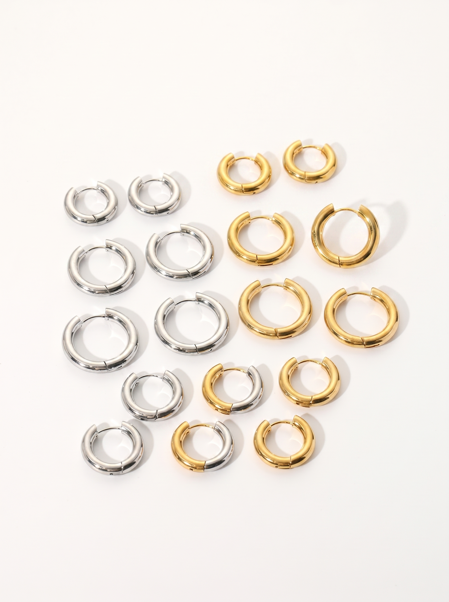 Cercle 18K gold huggie hoop earrings on bright clean white background