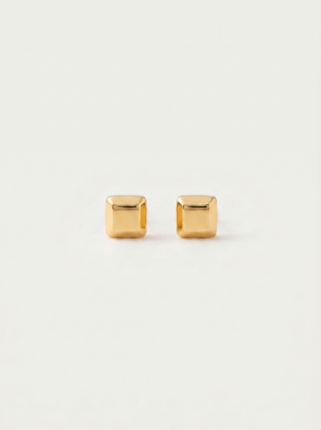 Carre chunky square gold cube stud earrings on warm off-white background