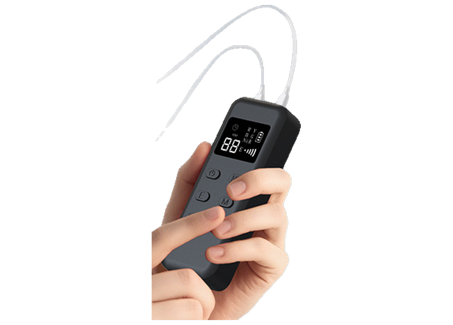 The hand-held controller: a lit display showing a minute countdown, the R, Y, B, G and NIR channel column, a brightness bar and a battery icon, with four soft keys below and both device cables entering the top edge