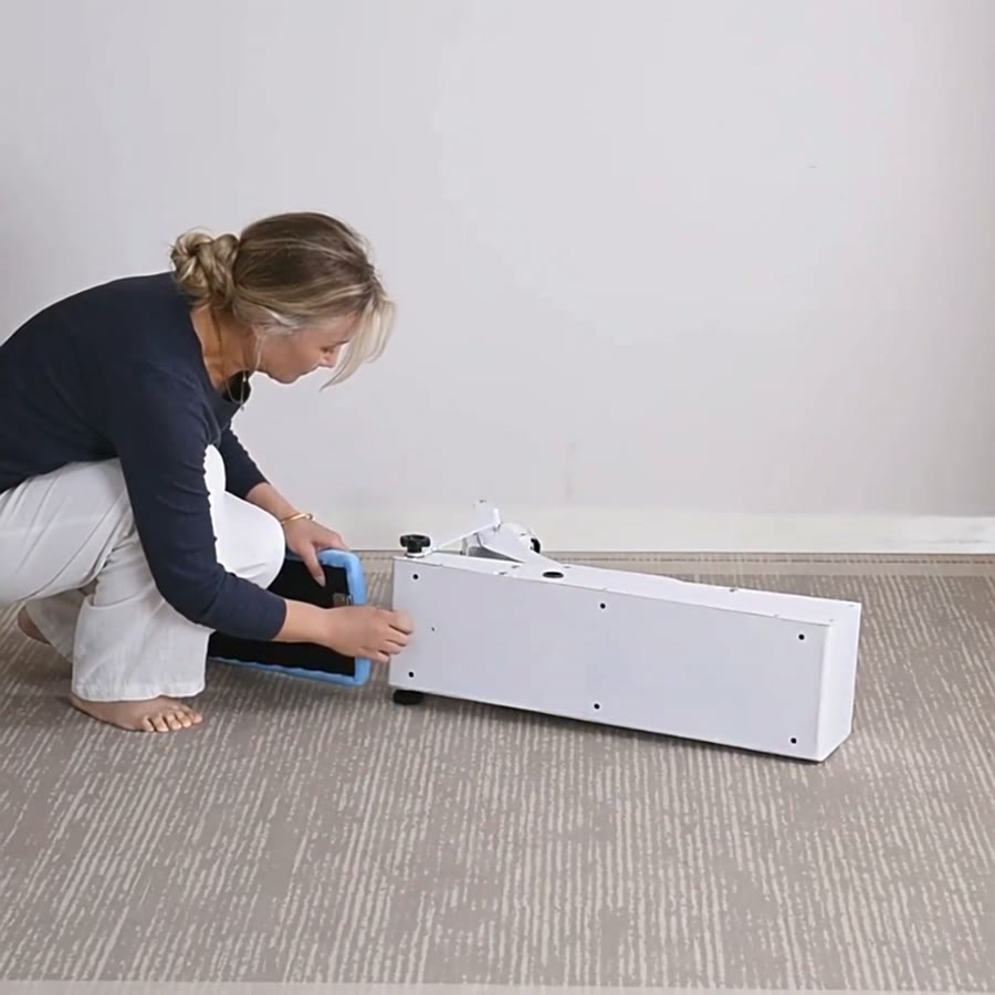 The sky-blue seat cushion being slid onto the end of the white base