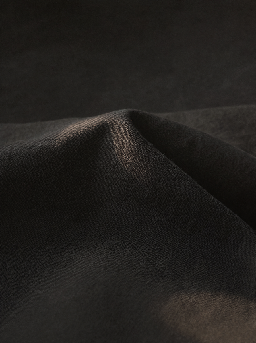 Deep charcoal linen folded in low evening light